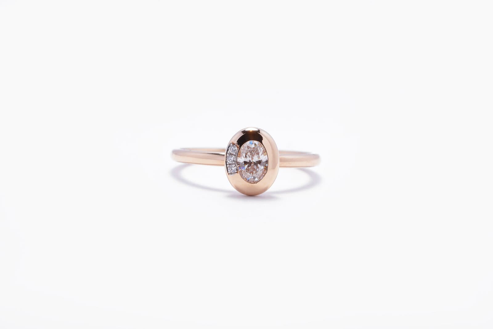 A sleek rose gold ring featuring an oval center diamond - 2